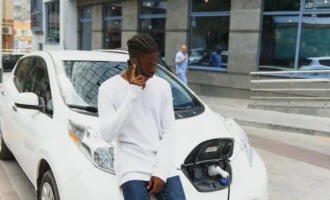 Man Using His Phone While His Car Is Charging 660 330X200